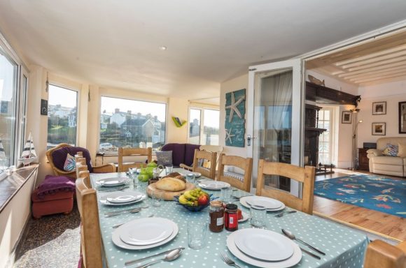 Bright dining area with a table set for a meal, overlooking a scenic view.